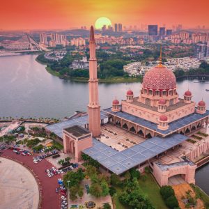 Aerial View Of Putra Mosque with Putrajaya City Centre with Lake at sunset in Putrajaya, Malaysia.