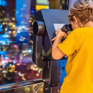 Little boy looks at Kuala lumpur cityscape. Panoramic view of Kuala Lumpur city skyline evening at sunset viewing skyscrapers building in Malaysia. Traveling with kids concept. BANNER, LONG FORMAT